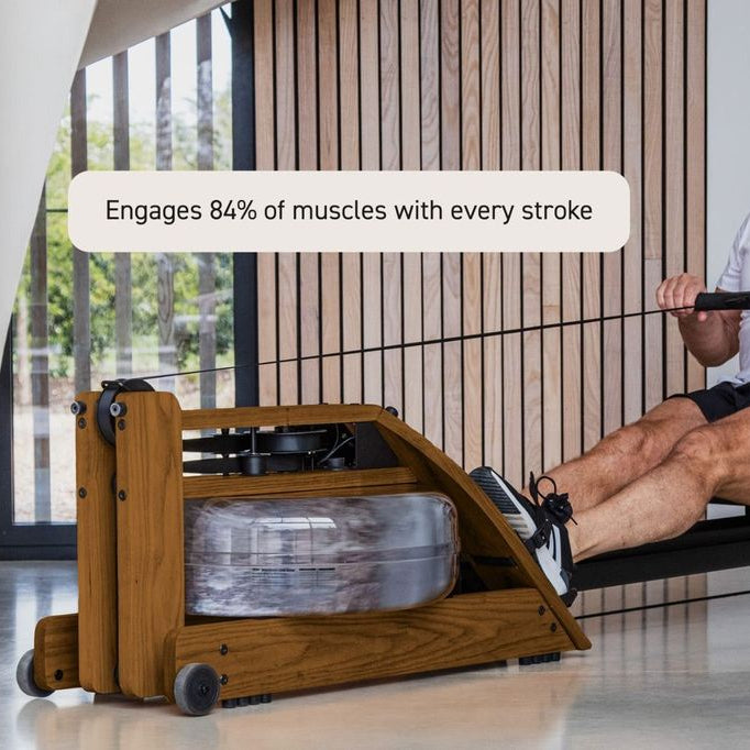 A man using a wooden rowing machine in a modern indoor setting, with a text overlay that reads 'Engages 84% of muscles with every stroke'.