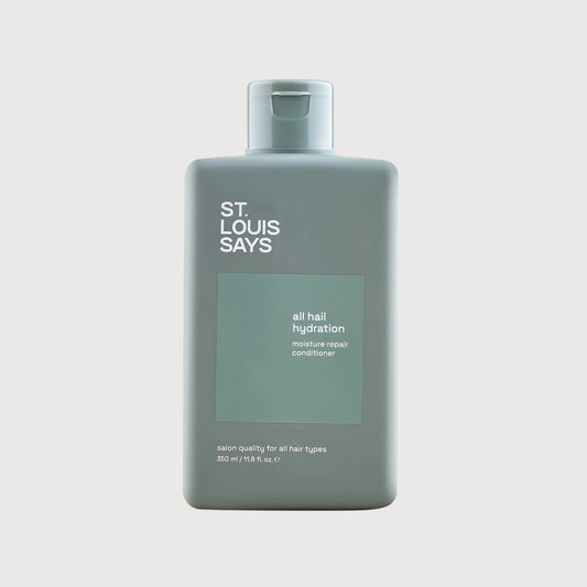 Bottle of 'St. Louis Says' hair product on a light gray background