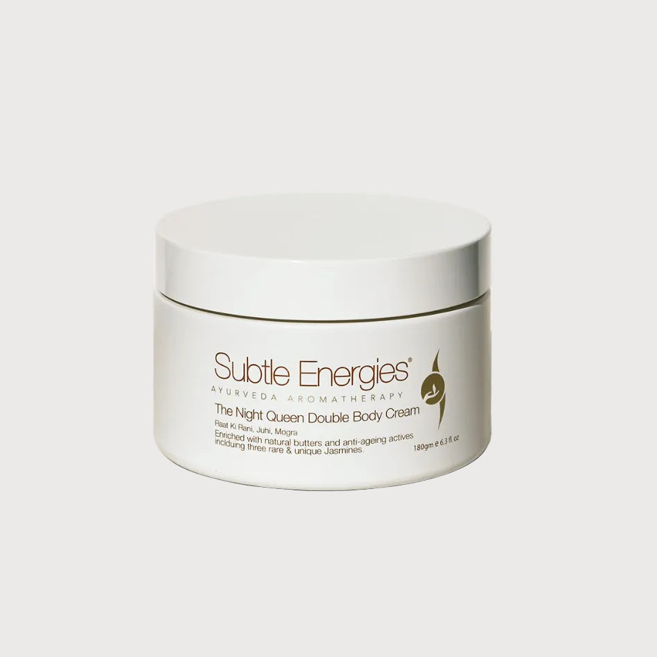 A white jar of Subtle Energies Ayurveda & Cosmetics 'The Night Queen Double Body Cream' on a light beige textured surface against a white background.