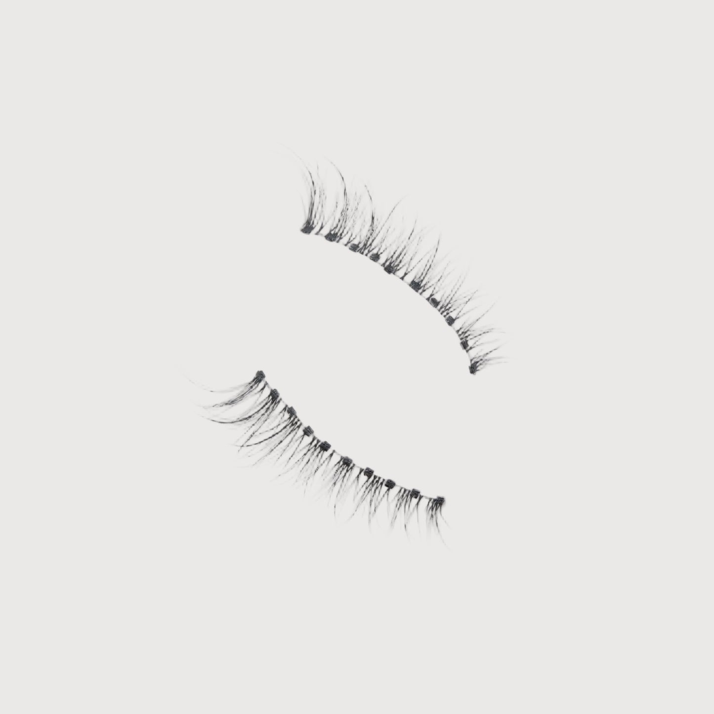 Pair of false eyelashes on a light gray background