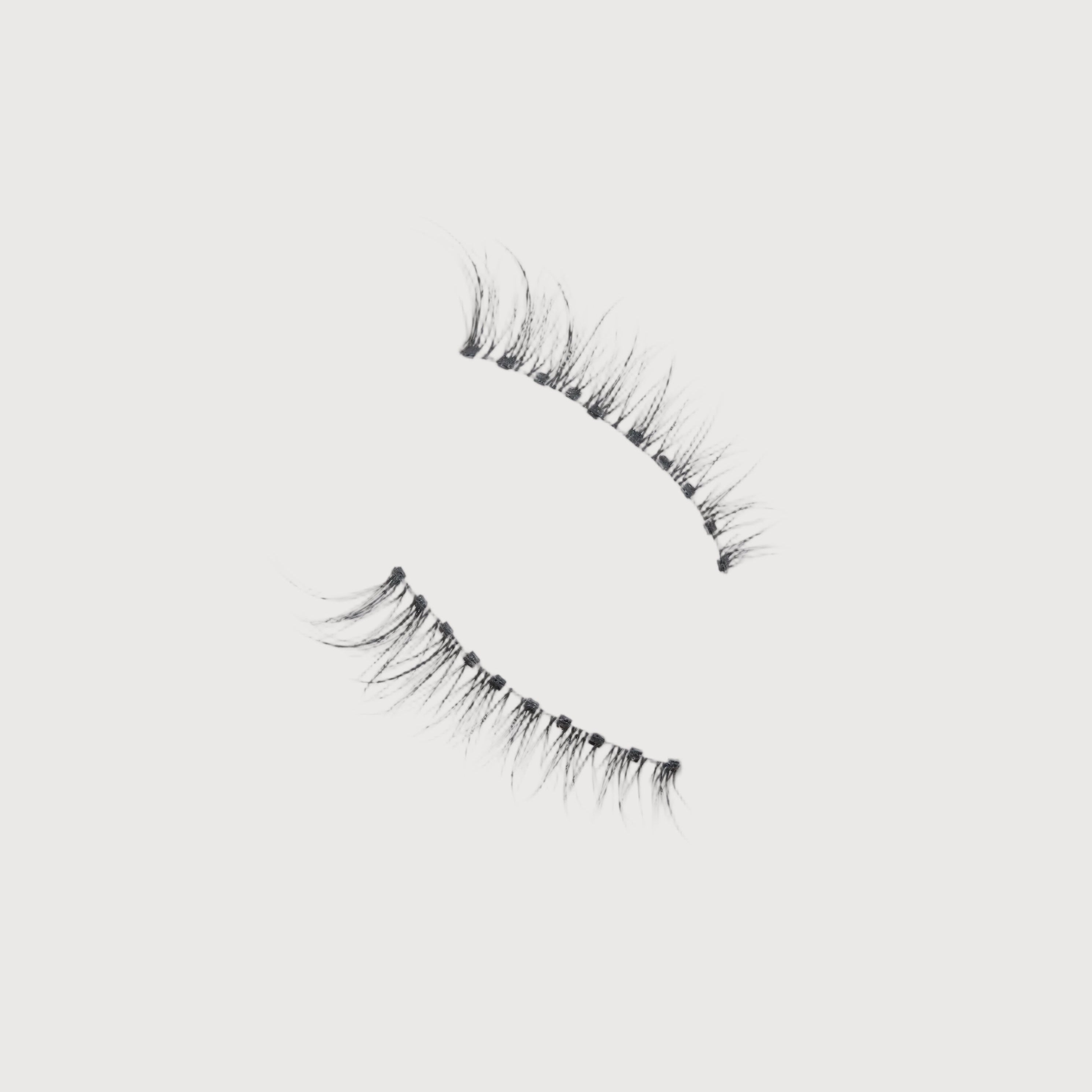Pair of false eyelashes on a light gray background
