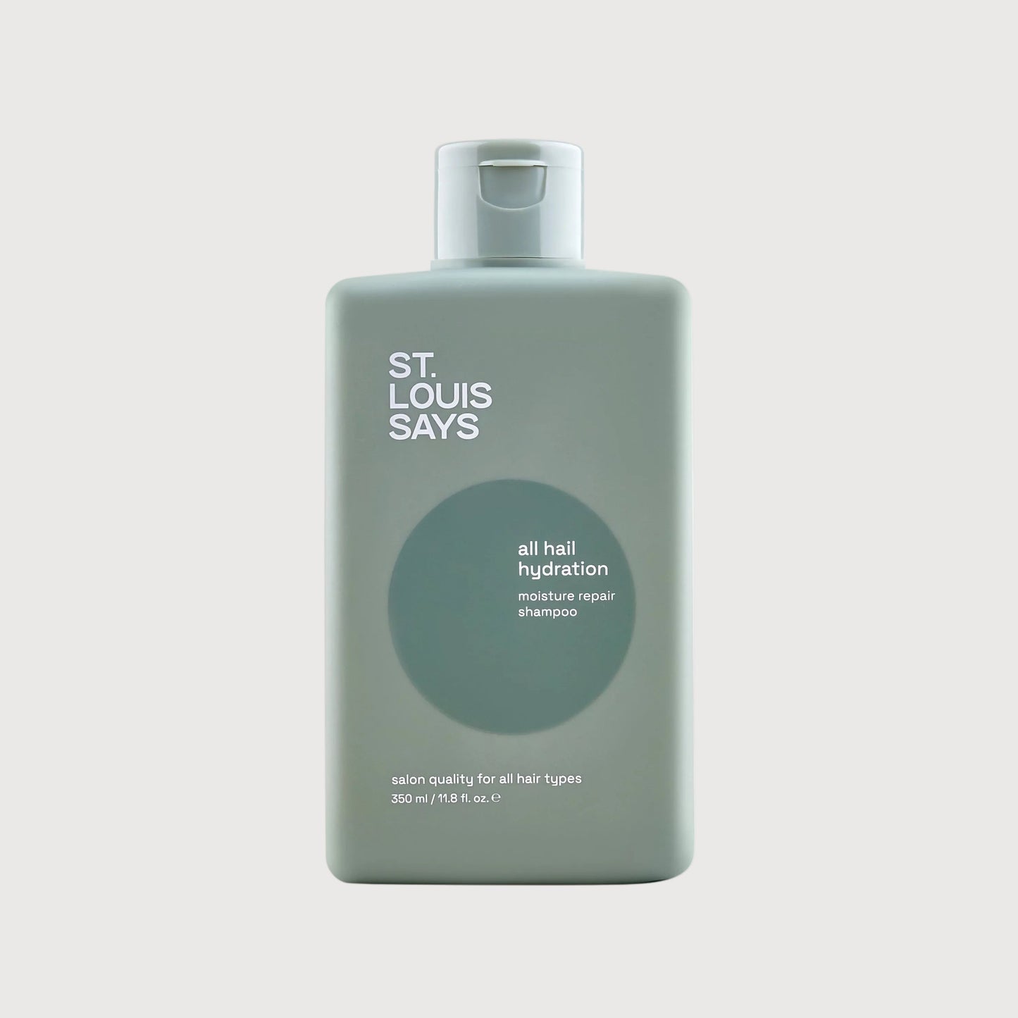 Bottle of 'St. Louis Says' hair product on a light gray background