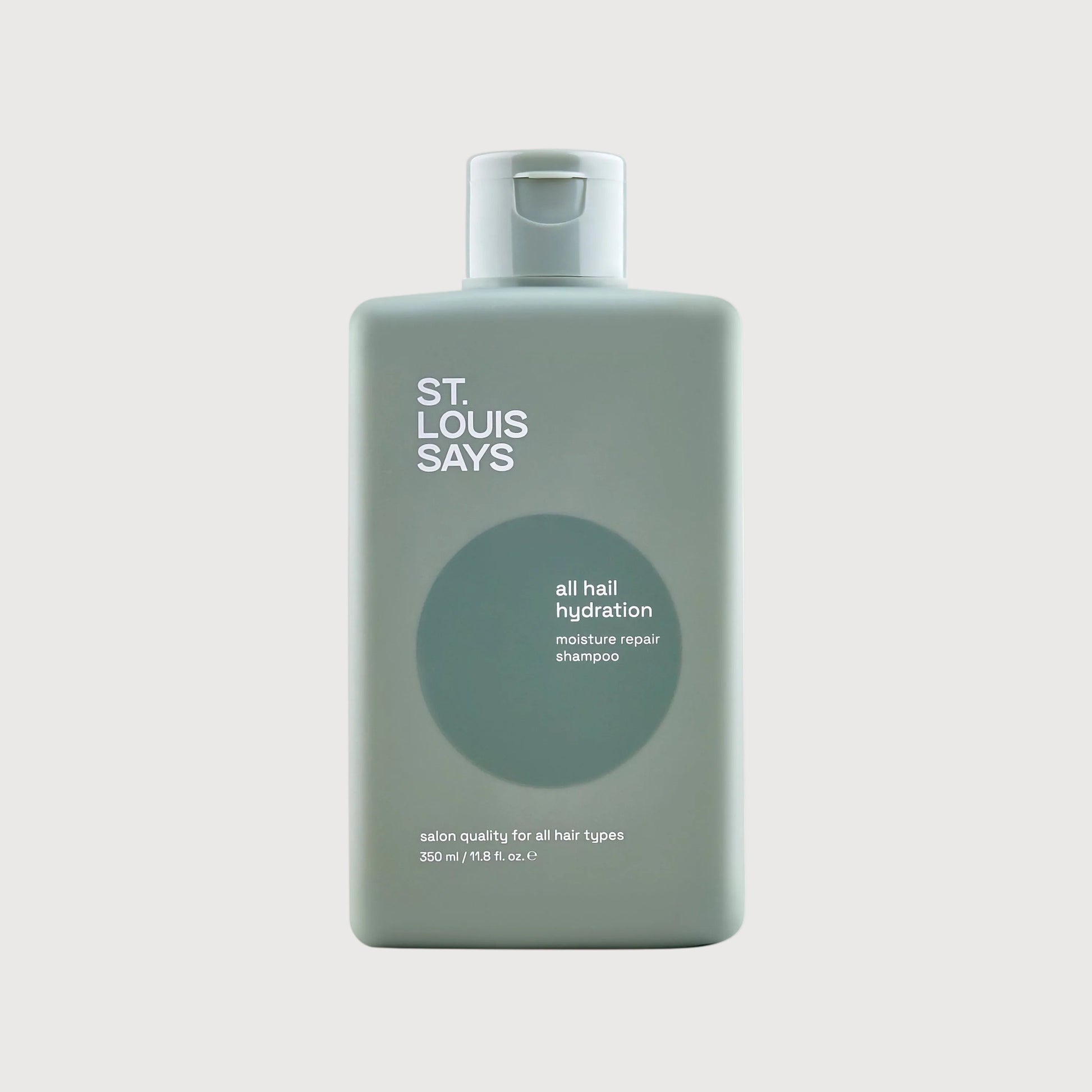 Bottle of 'St. Louis Says' hair product on a light gray background