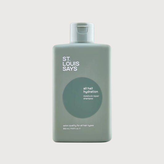 Bottle of 'St. Louis Says' hair product on a light gray background