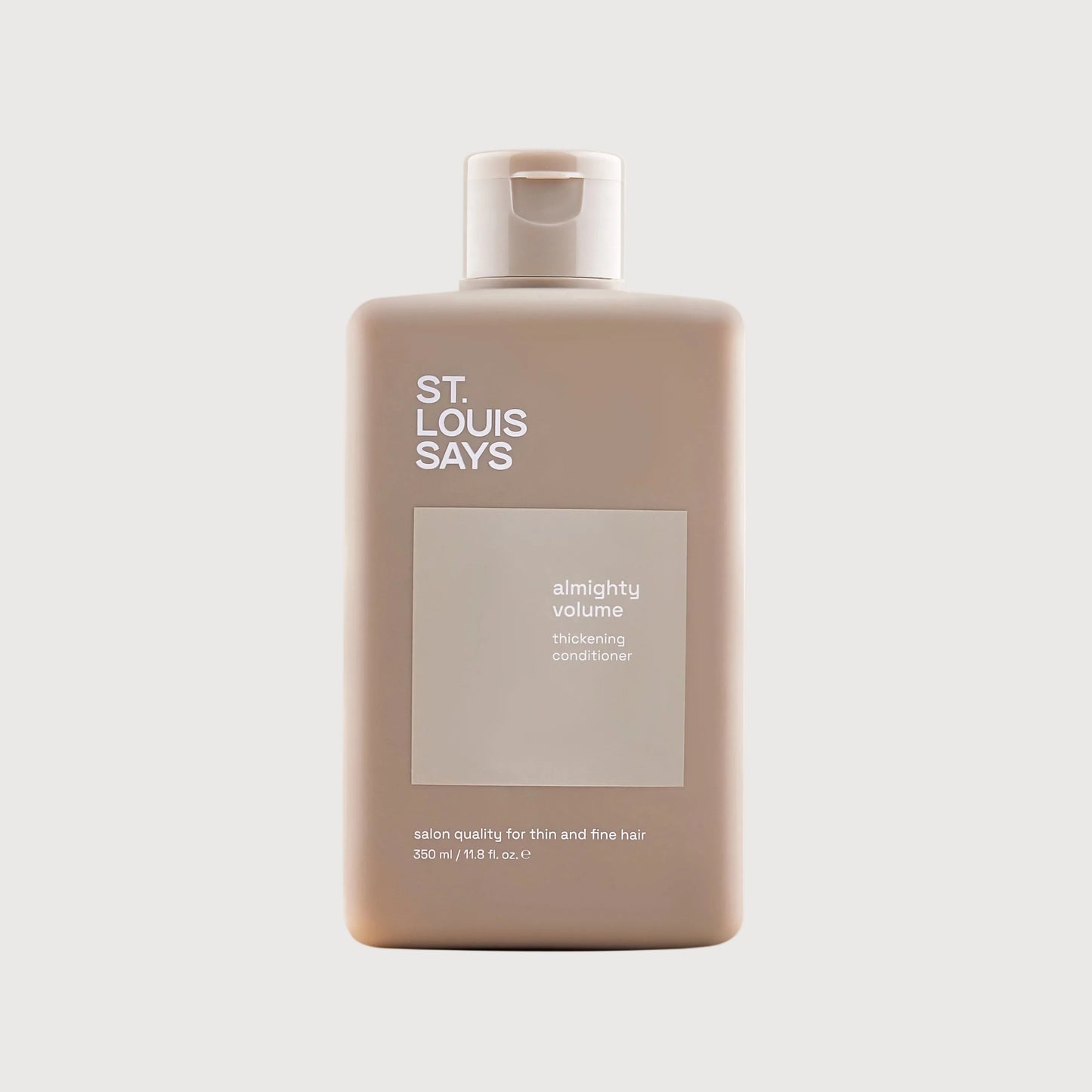 Shampoo bottle labeled 'St. Louis Says' on a light beige background