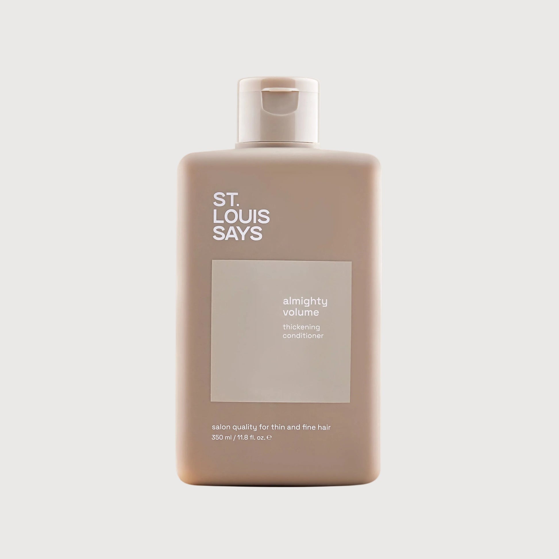 Shampoo bottle labeled 'St. Louis Says' on a light beige background