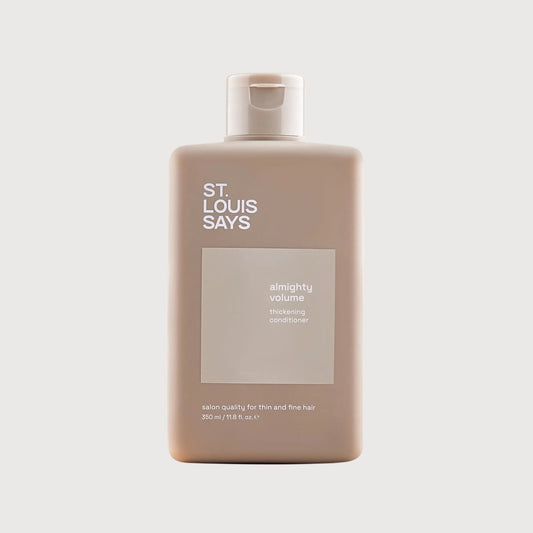 Shampoo bottle labeled 'St. Louis Says' on a light beige background
