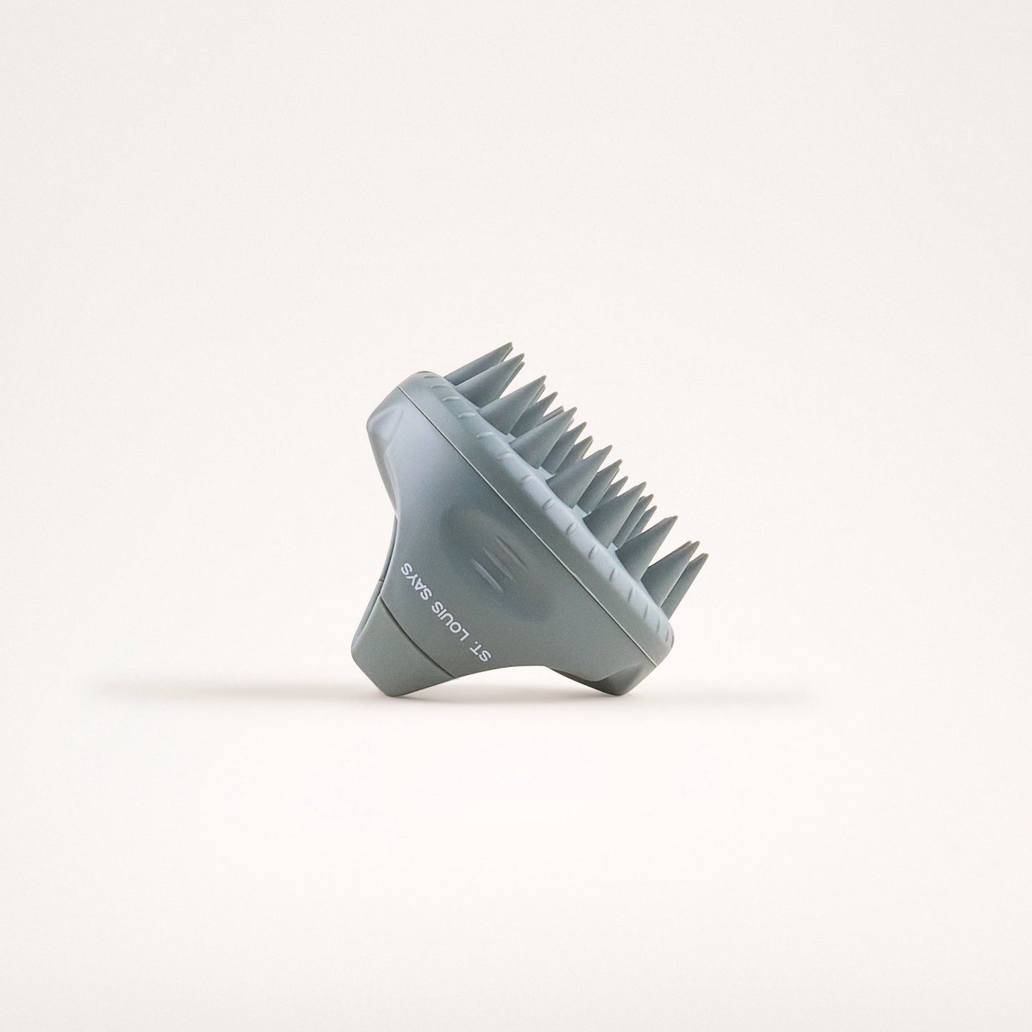 Blue scalp massager on a light beige background