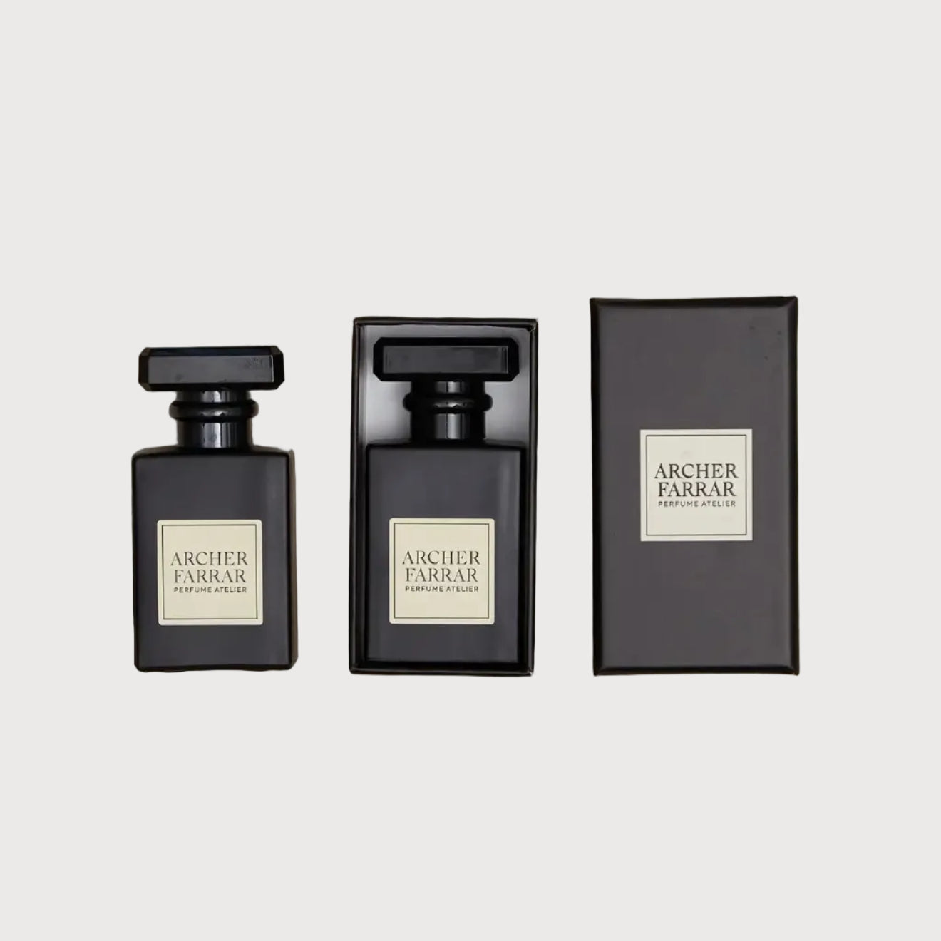 Three black perfume bottles with 'Archer Farrar' labels on a beige marble background