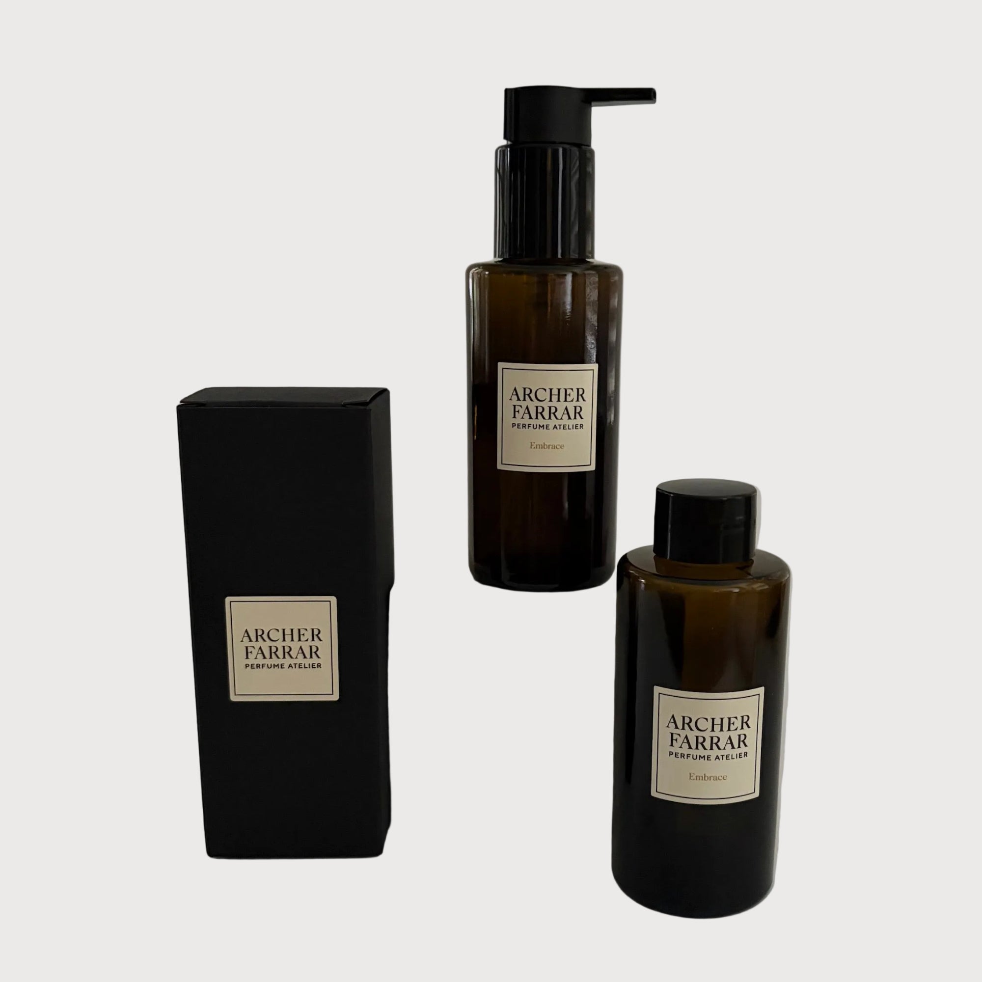 Two bottles and a box of Archer Farrar products on a light gray background