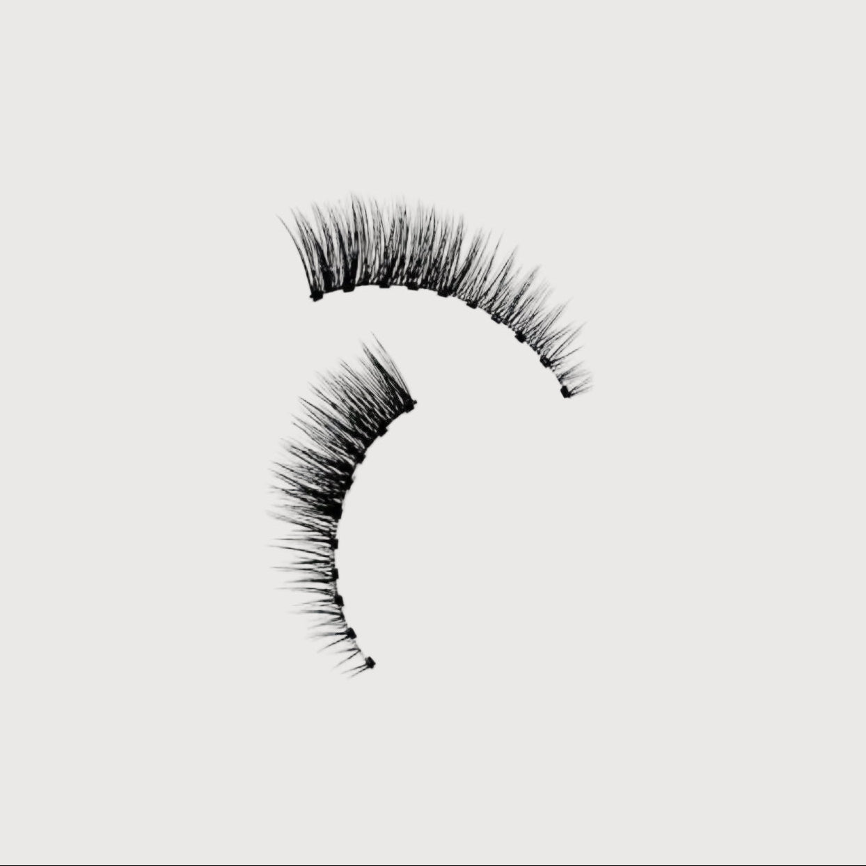 Pair of false eyelashes on a light gray background