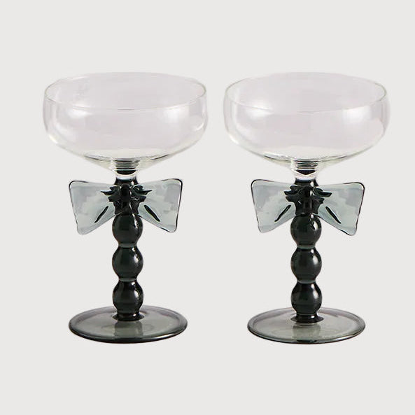Two black and white cocktail glasses on a light gray background