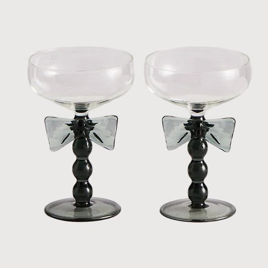 Two black and white cocktail glasses on a light gray background