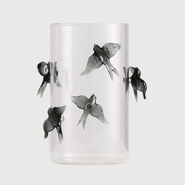 Clear glass tumbler with black fish illustrations on a white background