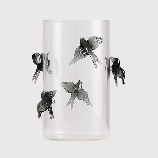 Clear glass tumbler with black fish illustrations on a white background