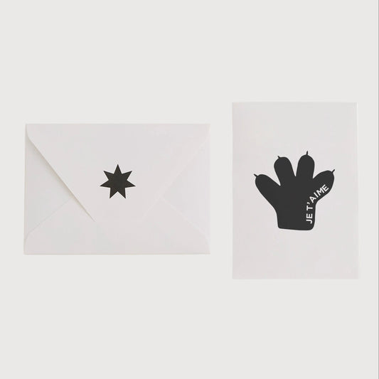 White card with black star design and white envelope on a light gray background