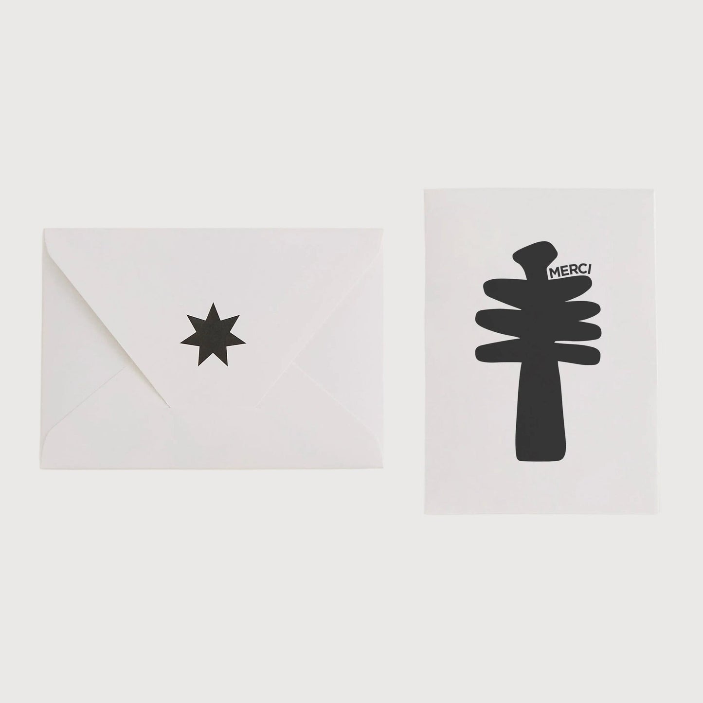 Two white cards with black star and tree designs on a light gray background