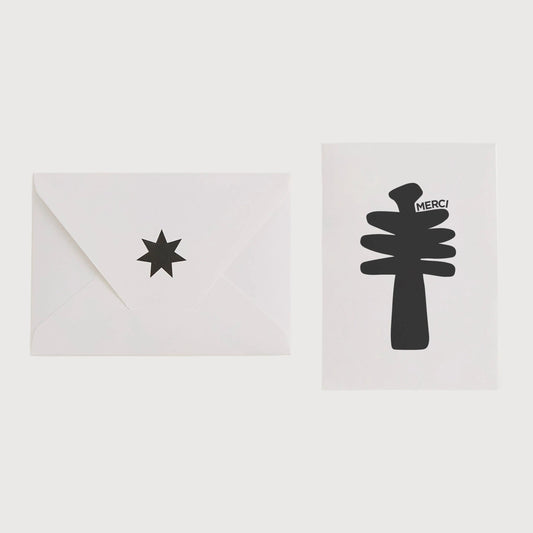 Two white cards with black star and tree designs on a light gray background