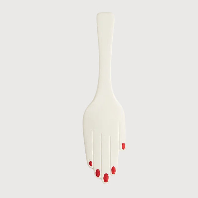 White fork with red nail polish on a light gray background