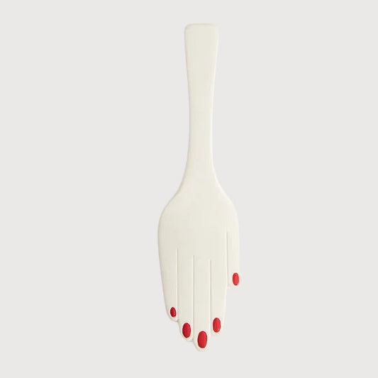 White fork with red nail polish on a light gray background