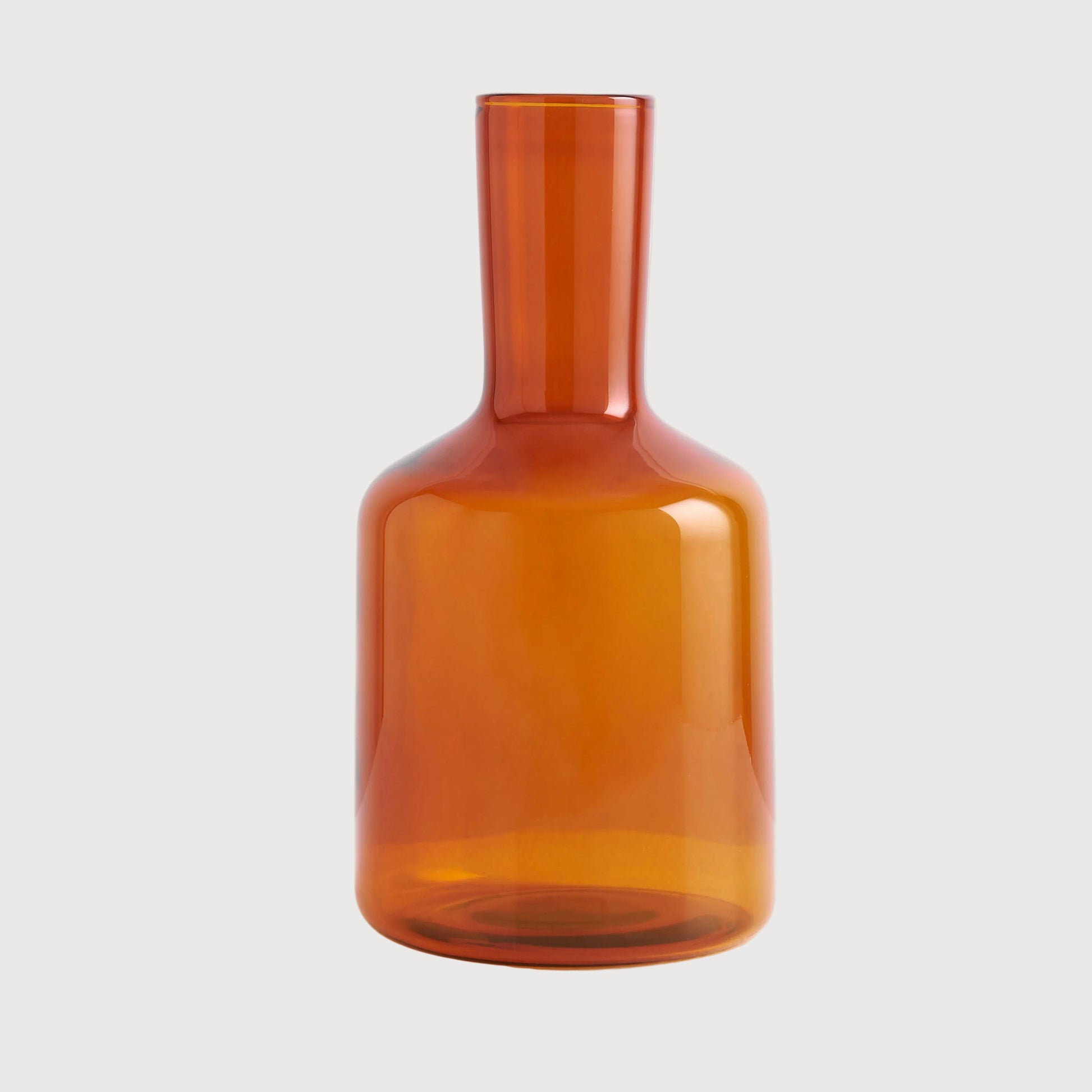 Amber glass carafe on a light gray background