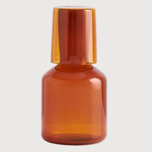 Amber glass bottle on a light gray background