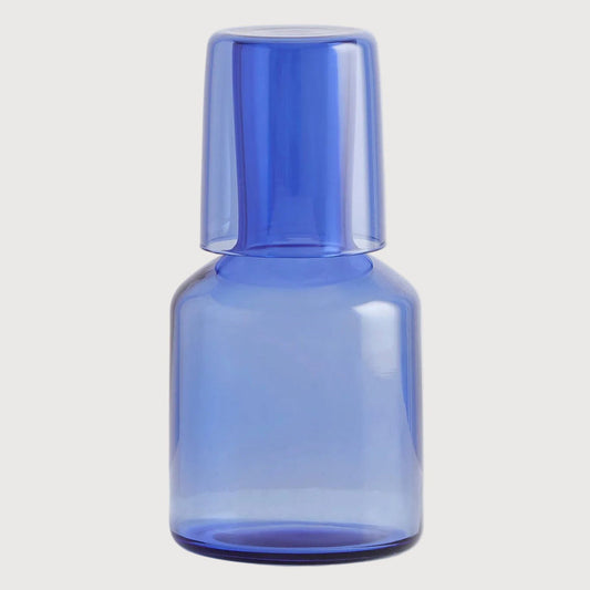 Blue glass bottle on a light gray background