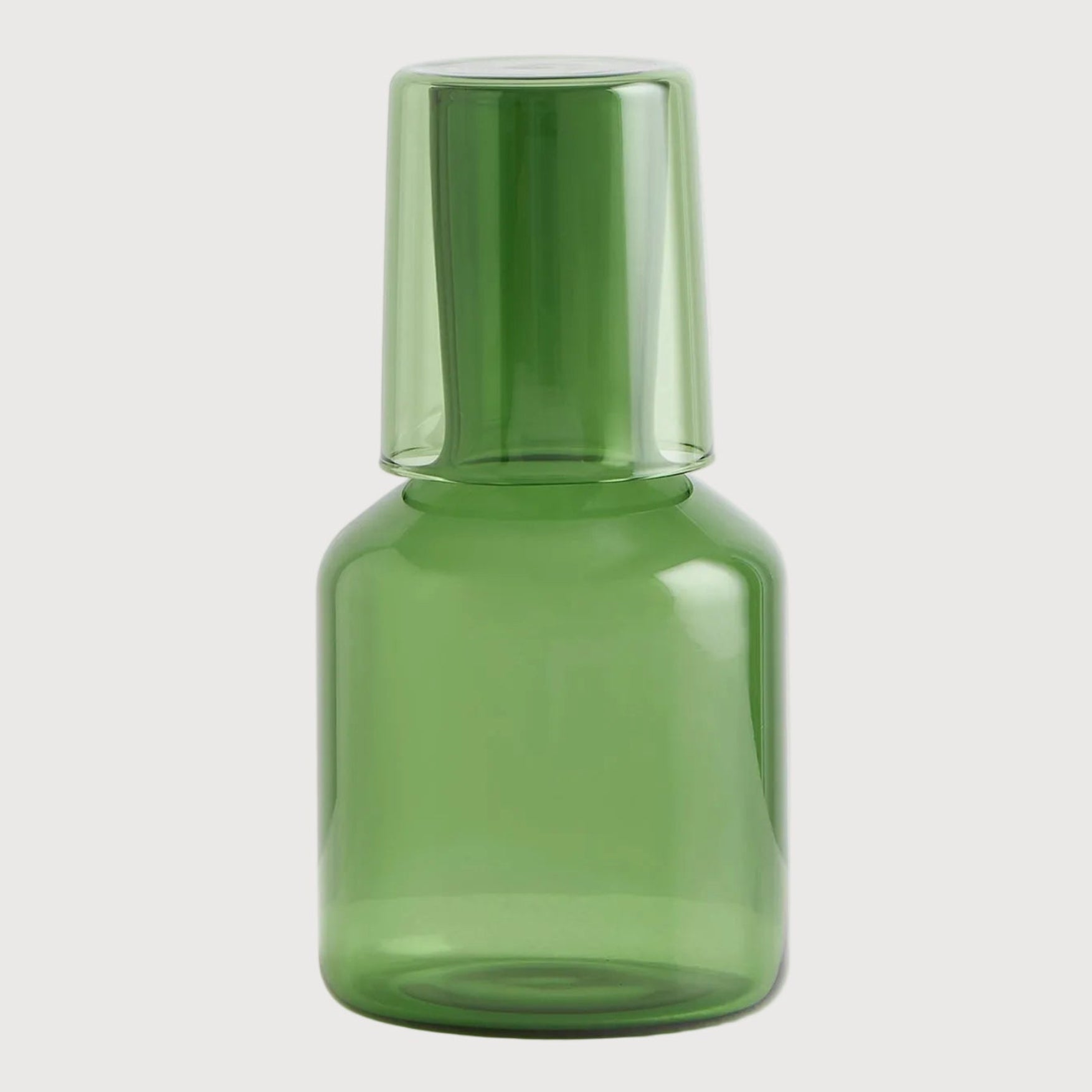 Green glass bottle on a light gray background