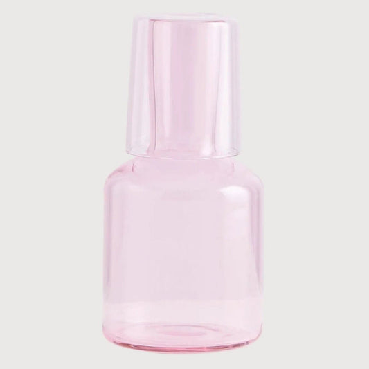 Pink glass bottle on a light gray background