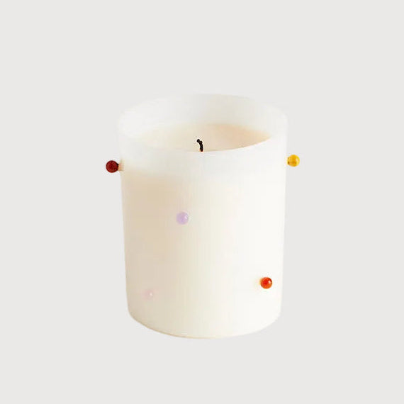 White candle with colorful wick on a white background