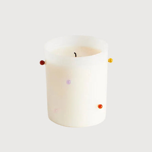 White candle with colorful wick on a white background