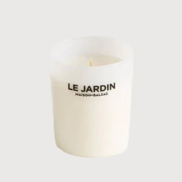 White candle with 'Le Jardin' branding on a white background