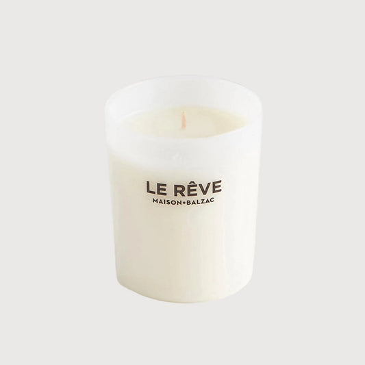 White candle with 'Le Reve' text on a white background