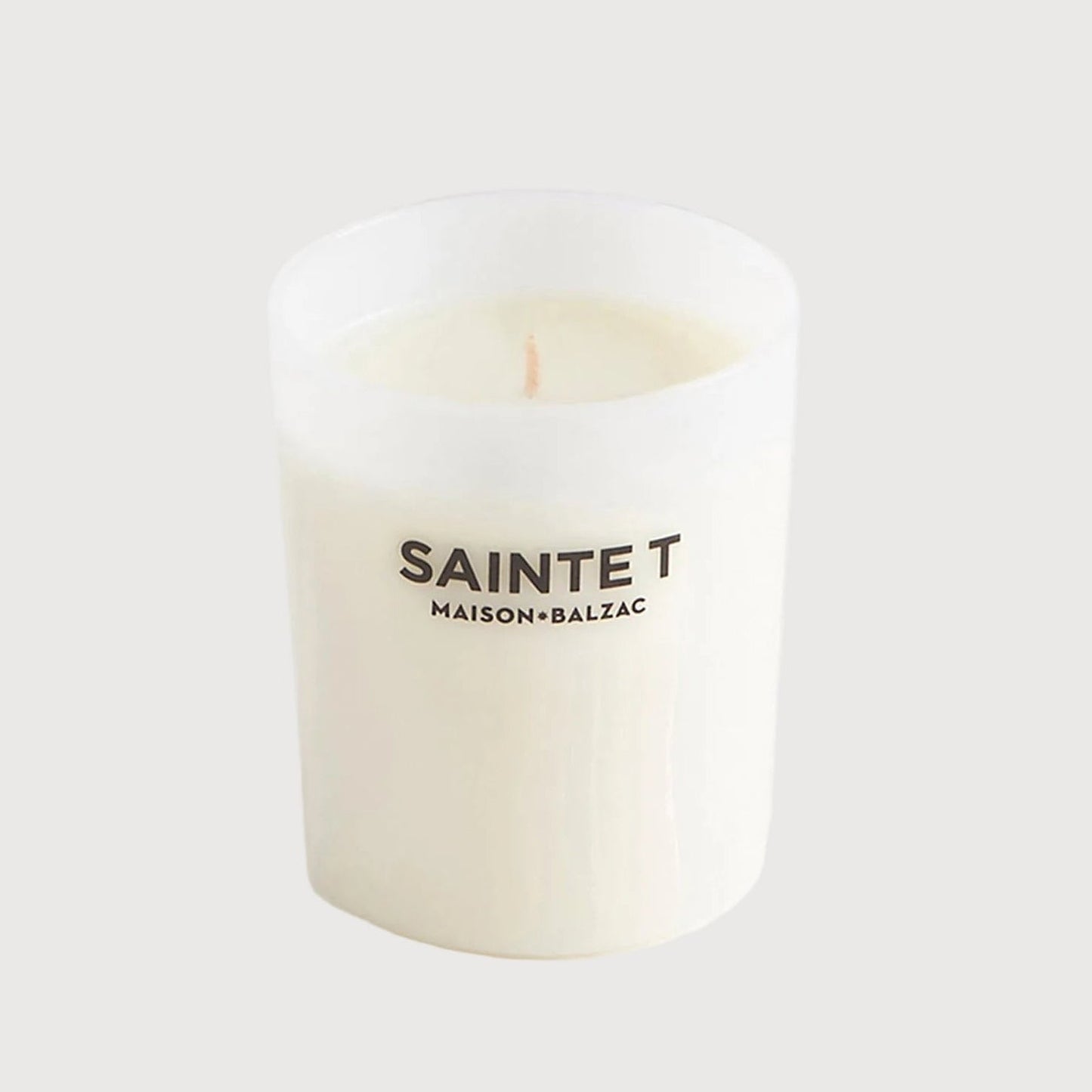 White candle with 'SAINTE T' branding on a white background