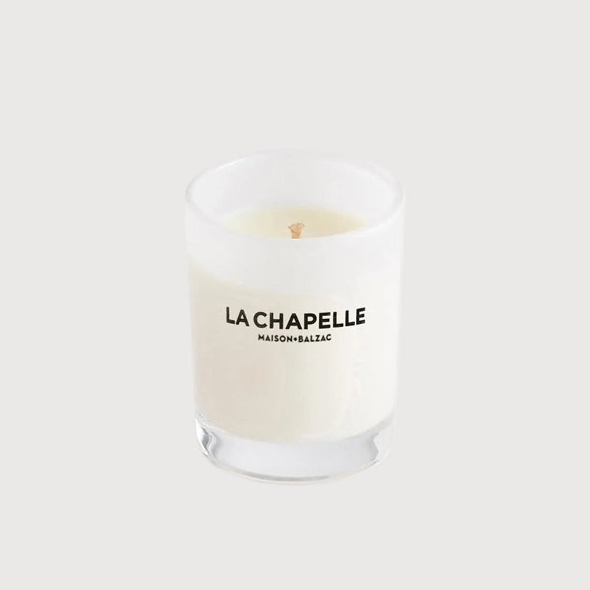 Candle in a glass jar with 'La Chapelle' branding on a white background