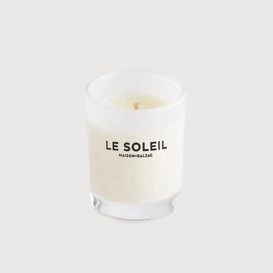 White candle with 'LE SOLEIL' branding on a white background