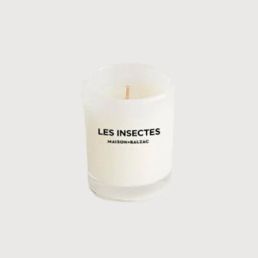 White candle with 'LES INSECTES' text on a white background
