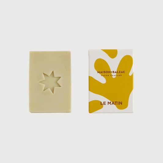 Bar of soap and its packaging on a white background