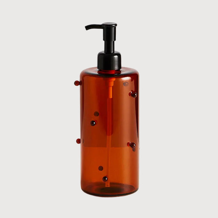 Brown bottle with black pump on a light gray background