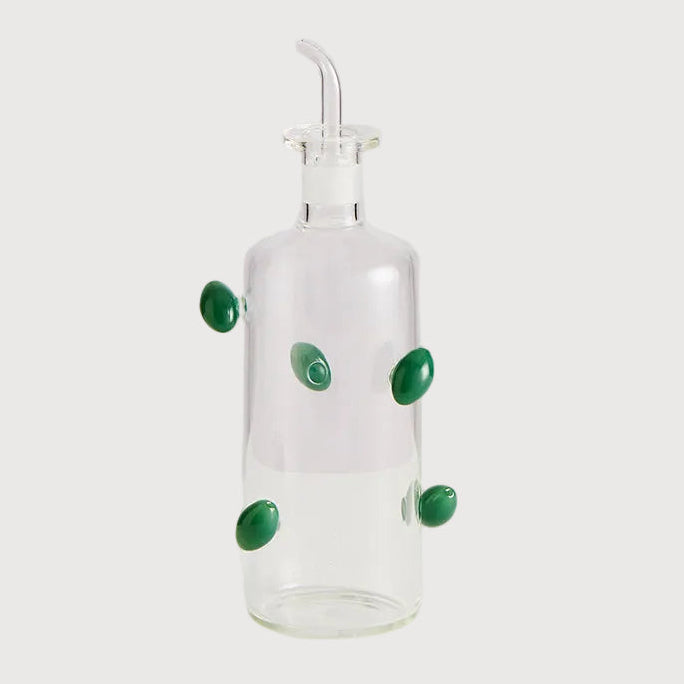 Clear glass bottle with green accents on a white background