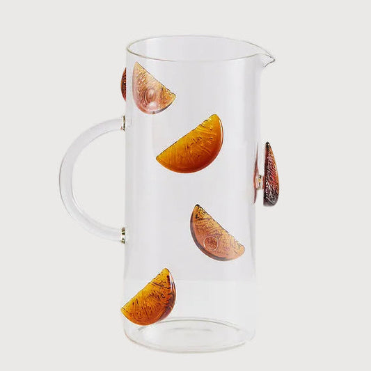 Clear glass pitcher with fruit design on a white background