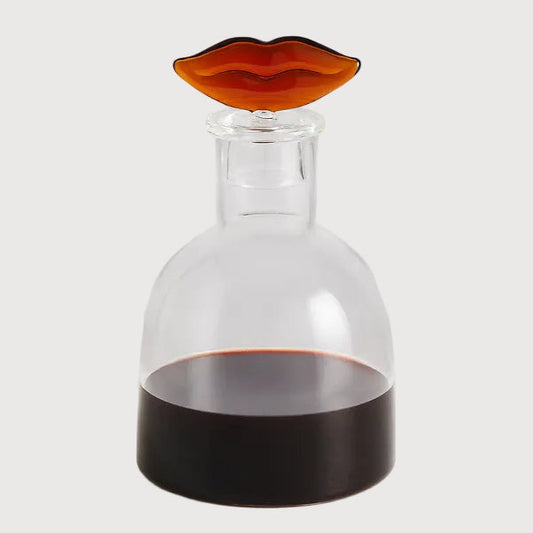 Glass decanter with a unique stopper on a white background