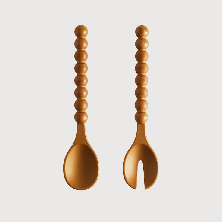 Wooden spoon and fork with textured handles on a light gray background