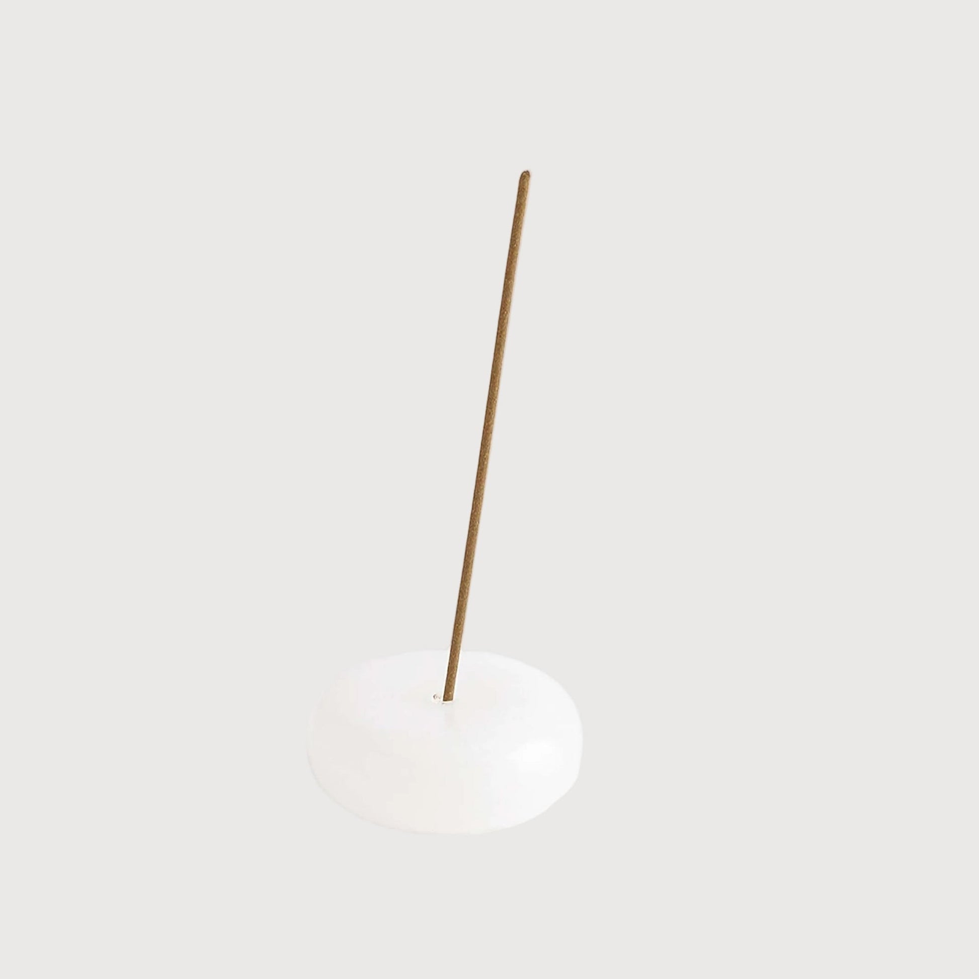 Minimalist pendant light with a white shade and gold fixture on a white background