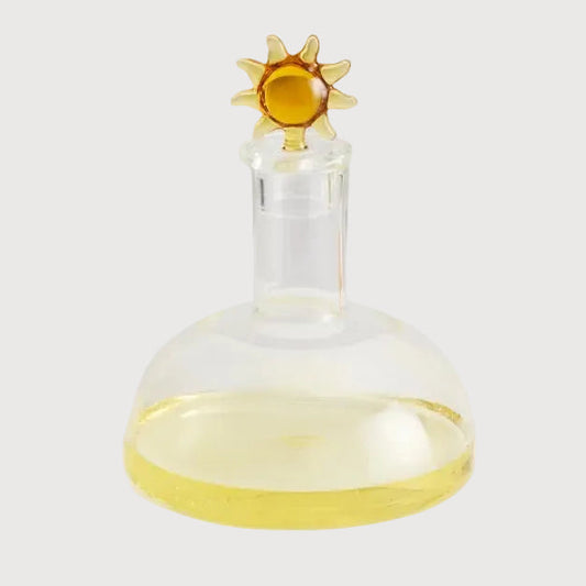 Glass container with a sun-shaped lid on a white background