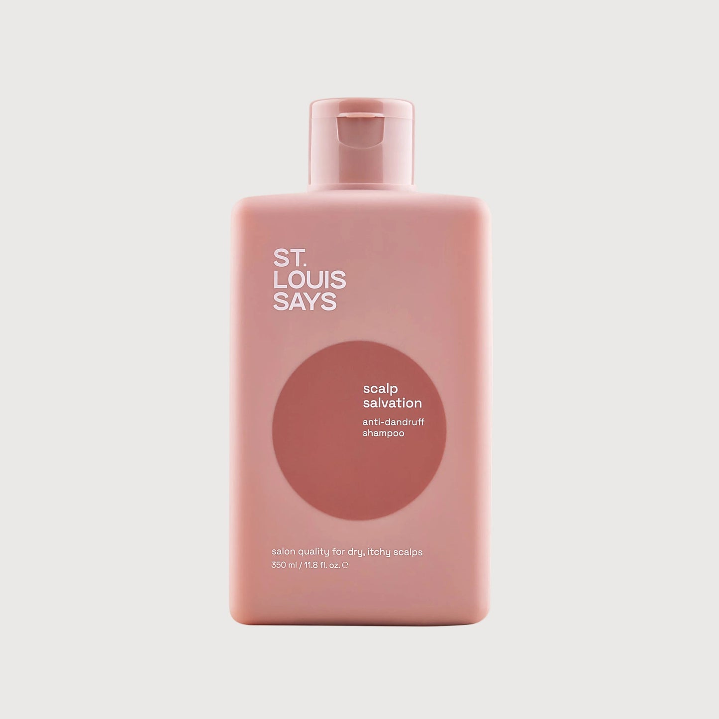 Pink bottle of 'St. Louis Says' scalp salvation product on a light gray background