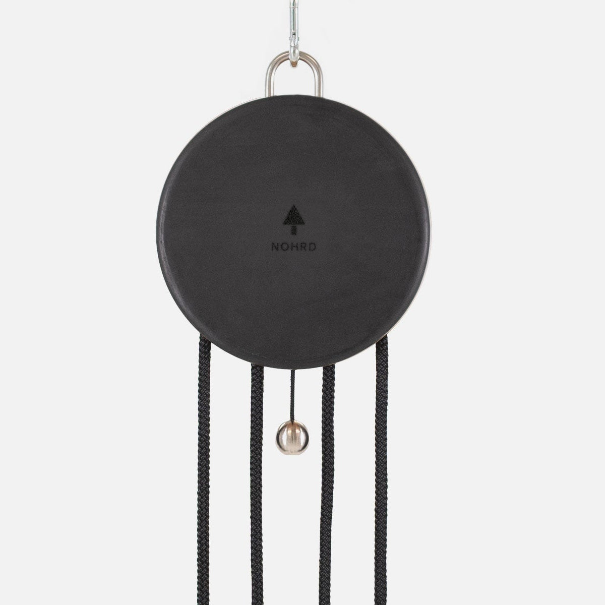 A minimalist black circular wall clock with hanging black cords, a small metallic ball, and a silver hanging loop, shown against a plain light gray background.