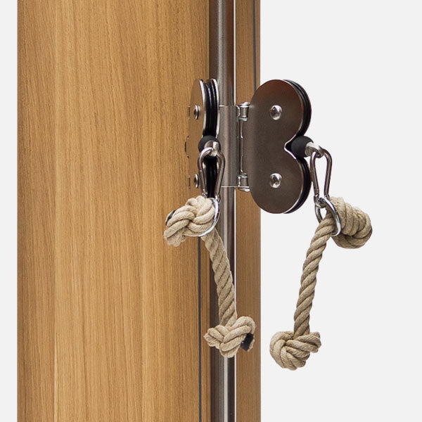 Metal door handle with knotted rope on a wooden door
