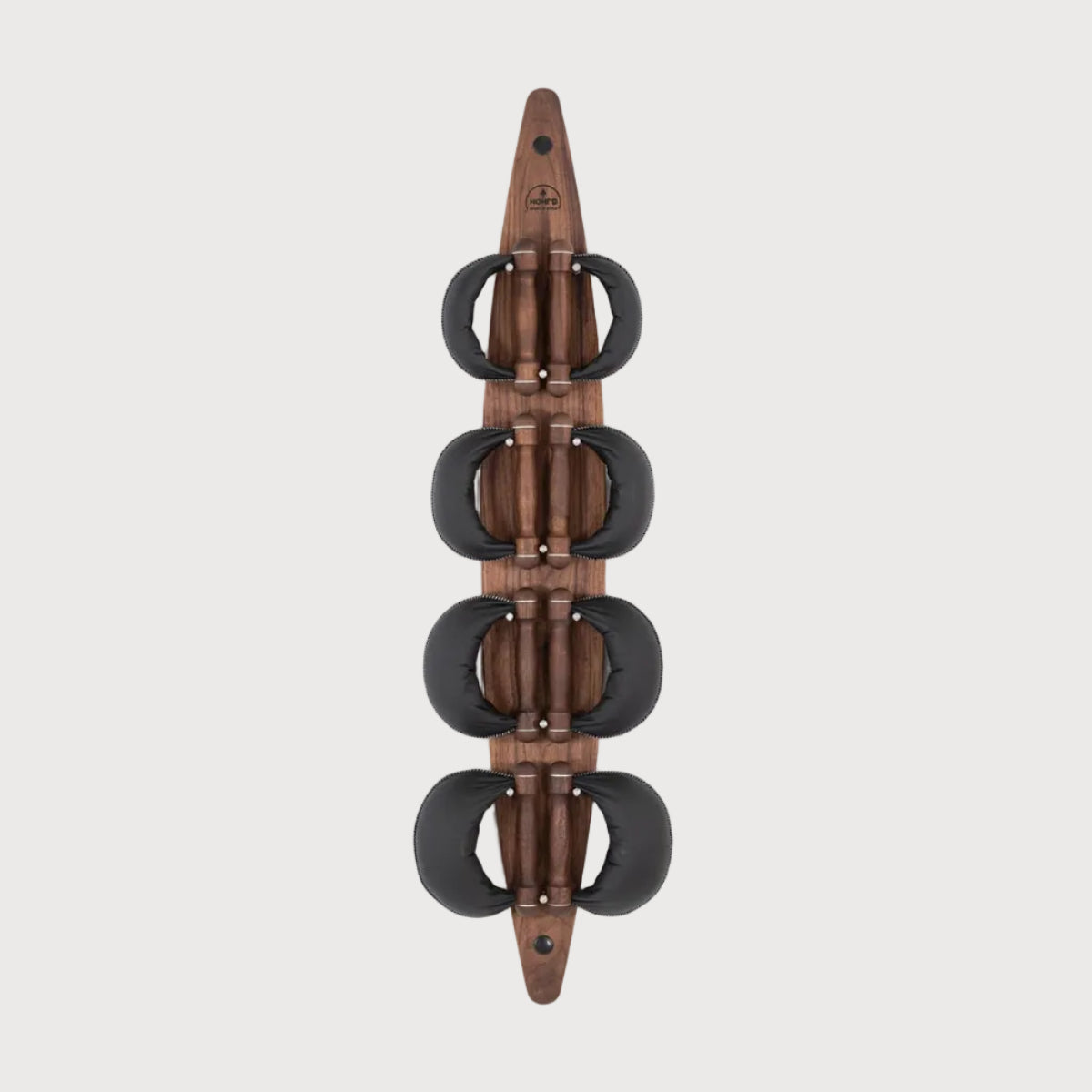 A wall-mounted wooden wall art sculpture featuring four stacked circular black elements on a vertical brown wood panel, shown against a light gray background.