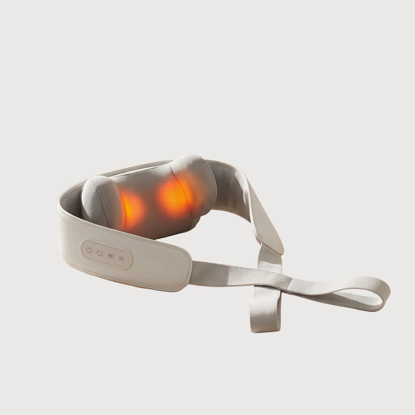 Massage belt with glowing red lights on a beige surface with towels and a plant in the background